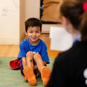 Camp Corlears - a 5/6s camper smiling on the carpet