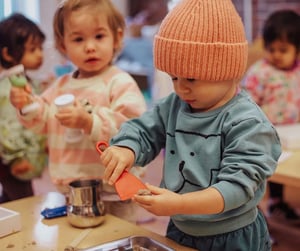 Student using a tool to manipulate play dough with his hands