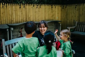 A Camp Corlears counselor surrounded by happy campers