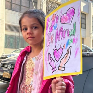 a student holds a sign calling for more kindness